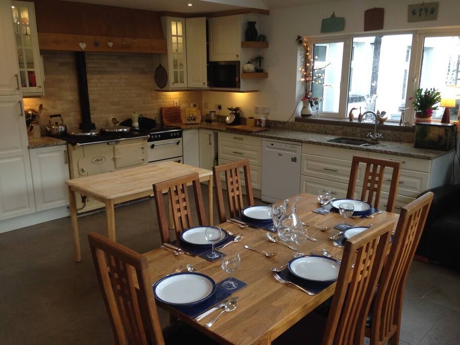 Large kitchen with aga stove and electric cooker. Natural clothes dryer suspended from ceiling.