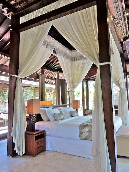 King size bed in master suite -- lay down and look up to see the traditional carving! Master bedroom with corner desk and access to the deck and infinity pool