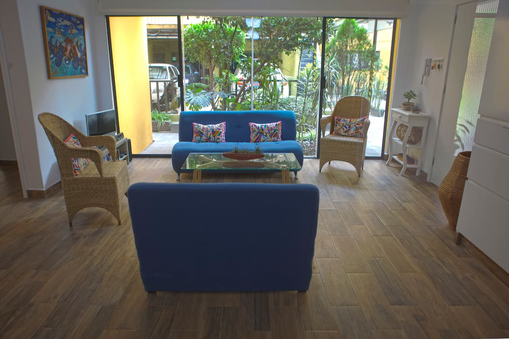 Light-filled living room featuring chuspata chairs from Michoacán and hand-embroidered tenango pillows.