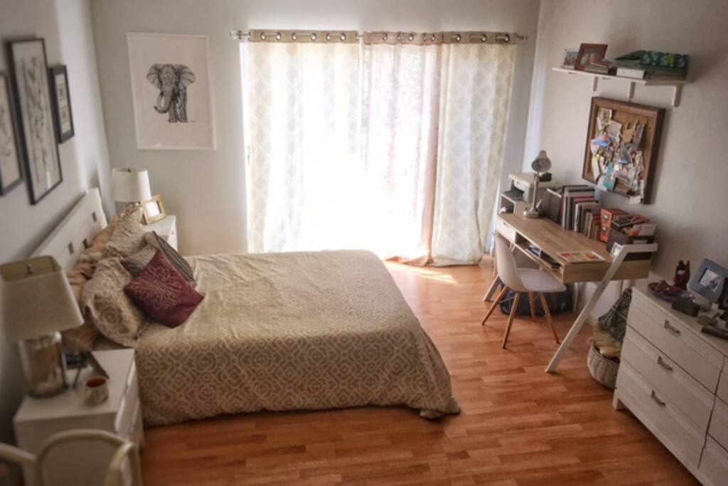 The bedroom also has a desk and two night tables.