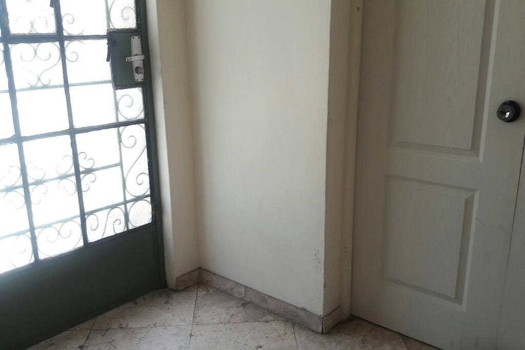 Otra puerta de ingreso al lado de la puerta de entrada a la vivienda, apenas 2 escalones del nivel del suelo.