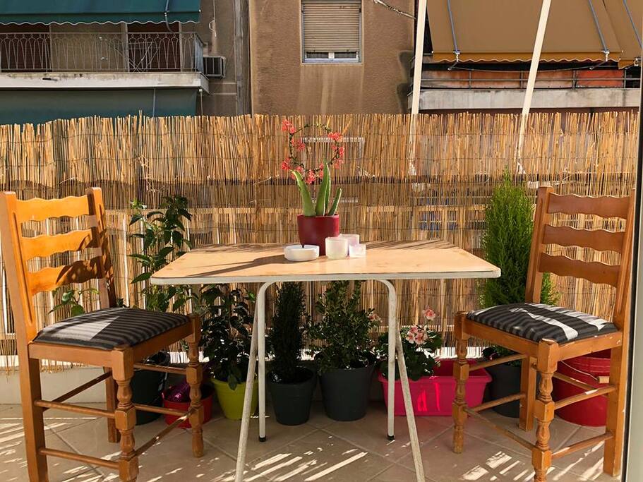 Balcony with 2 chairs and table.