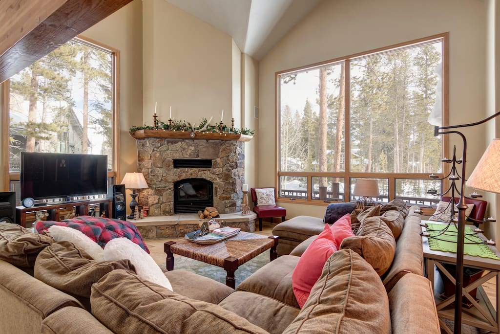 Main floor family room with woodburning fireplace, huge couch, big windows with great views, tv etc all next to dining room table and kitchen for family stays engaged during dinner prep etc.