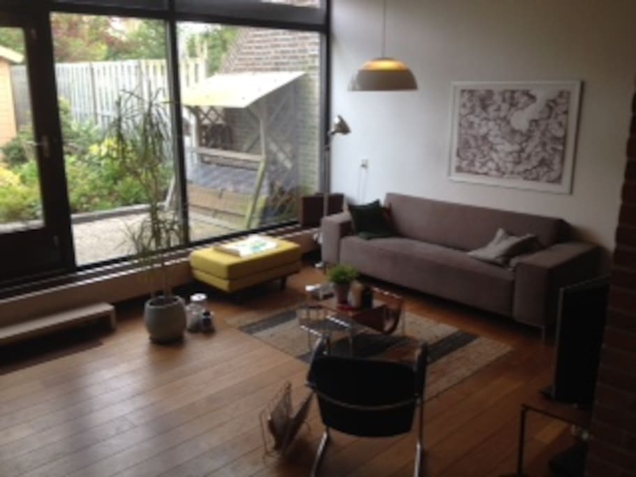 Leuke woonkamer met grote ramen naar de tuin.
Lovely living room with large windows to the garden.