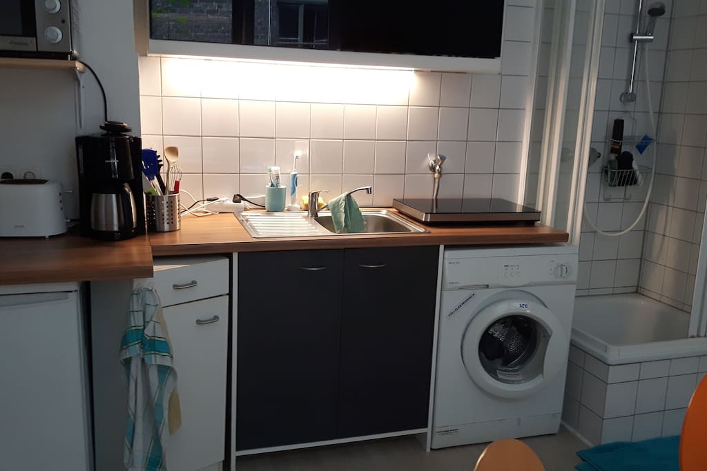 Hier sieht man die Küche wo sich die Waschmaschine der Herd und Kühlschrank befinden.
Auch die Dusche ist Offen und Befindet sich im Esszimmer.