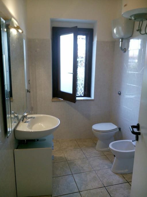 Il bagno con la doccia dietro la porta sulla destra