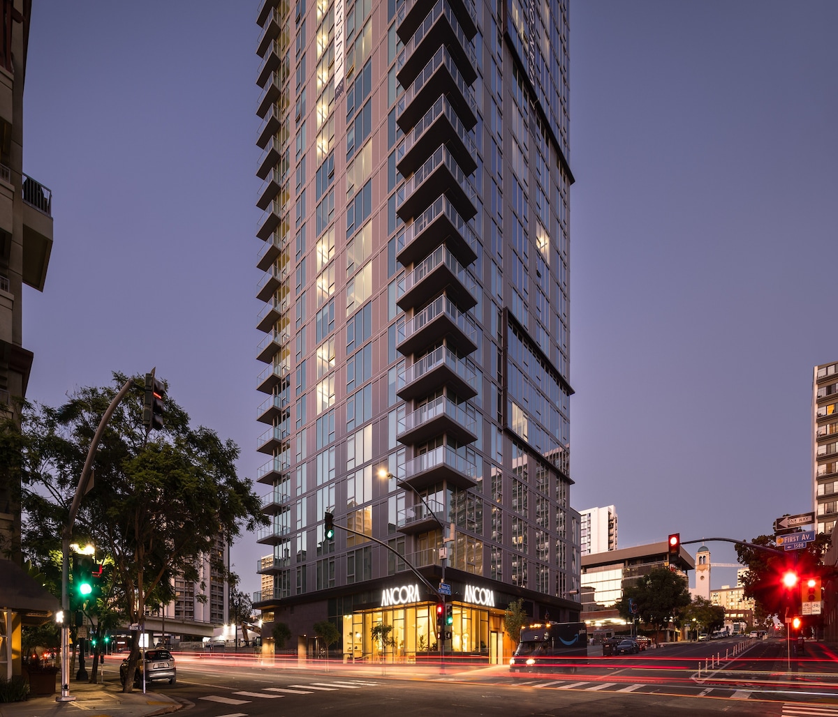 Impresionante edificio de departamentos de gran altura con una moderna arquitectura de vidrio, iluminado con una cálida luz interior, que ofrece una vida urbana en un vibrante paisaje urbano.