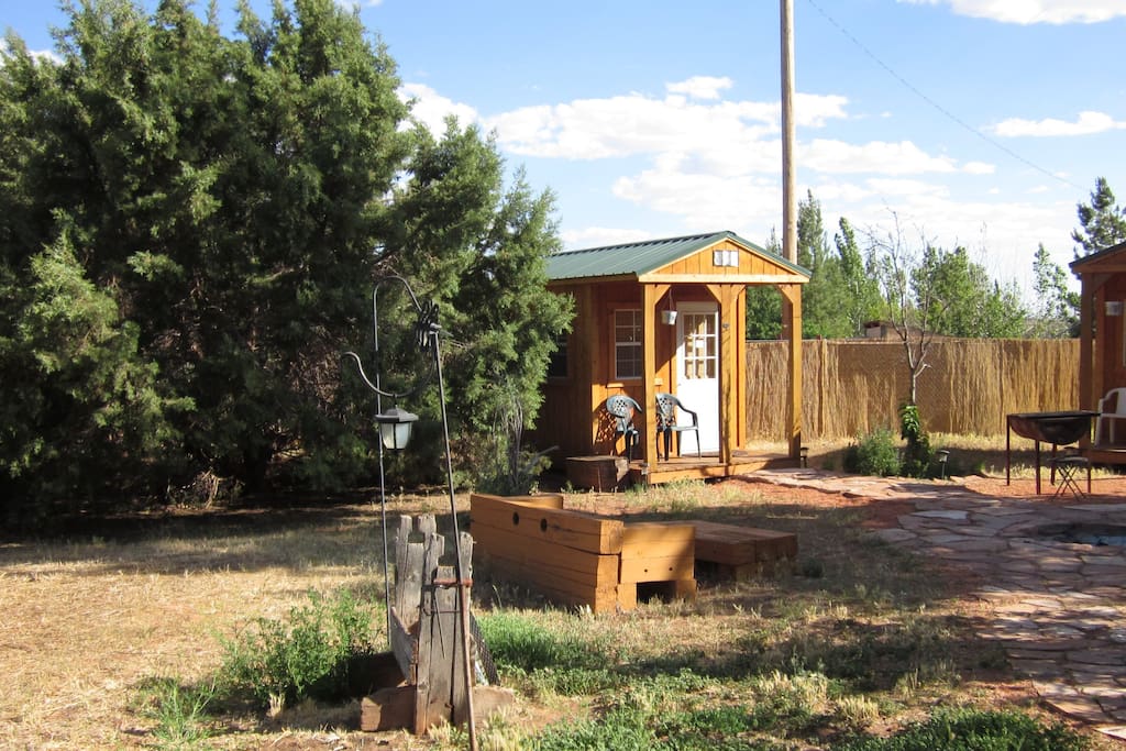 Bunkhouse sits next to large cedar tree.