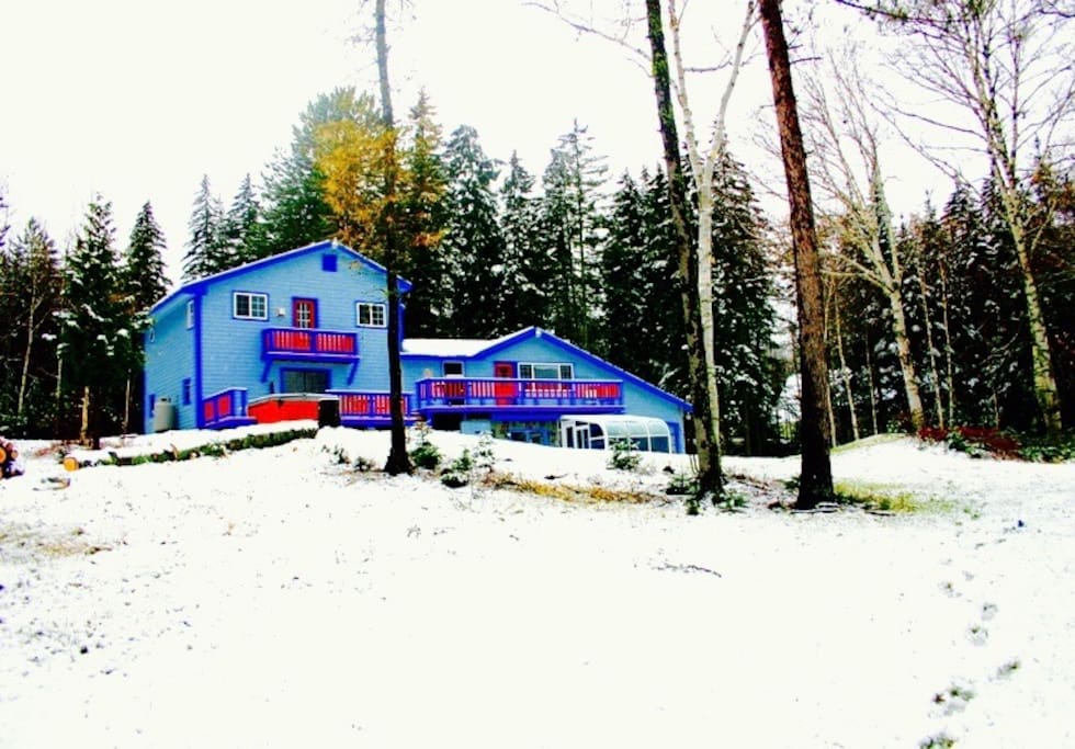 A winter view of Xanadu House, set on a small hill looking down at the pond and Bigelow Mountain,