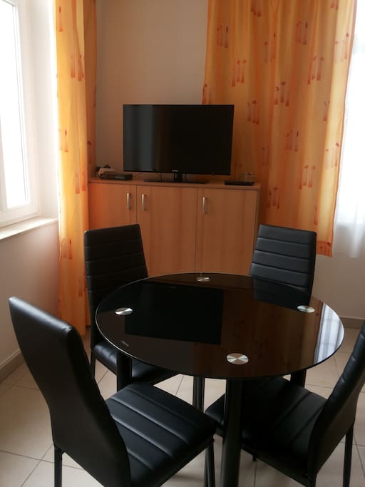 Main room, living and dining room, bedroom, folding couch and kitchen table, flat TV