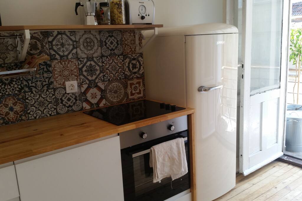 Kitchen: washing machine, dryer, oven & hot plates, fridge.