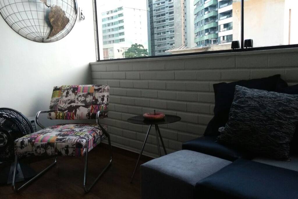 Espaço relax com mesinha e apoio e puffs.