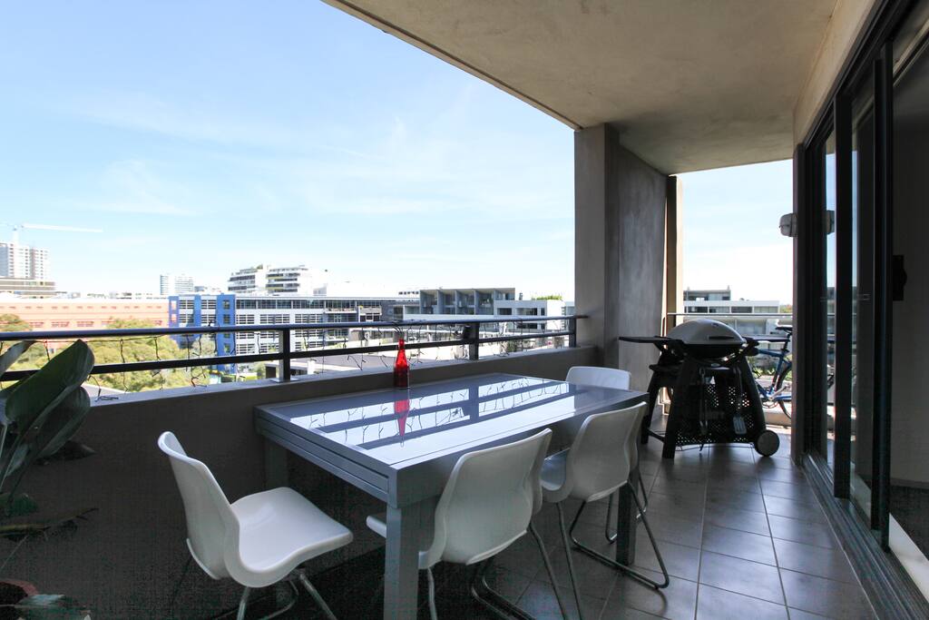 Balcony with seating and bbq with views of the city and surrounding area.