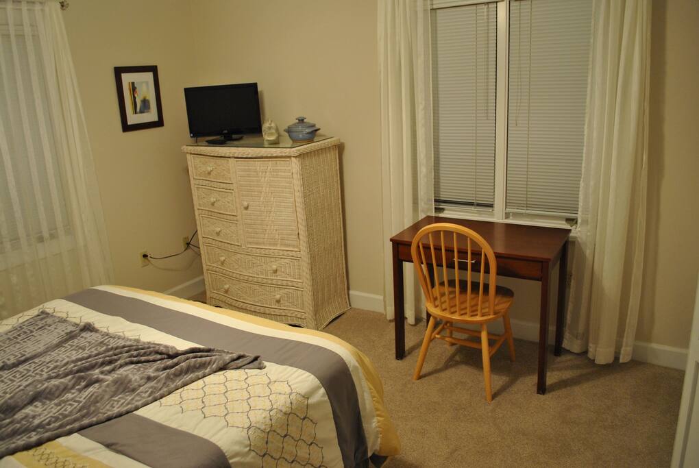 The wicker room has a desk and TV with local channels.