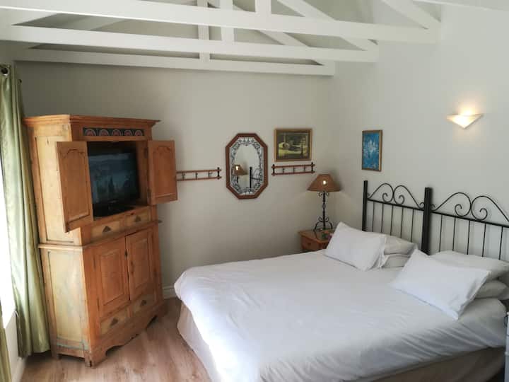 מיטת קינג סייז בחדר שינה ראשי עם חדר רחצה וחדר הלבשה עם נוף לבריכה ולגינה 