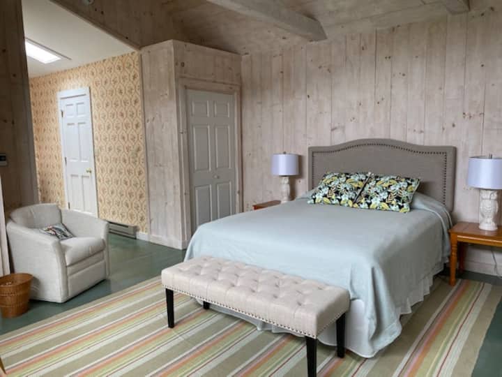 Დიდი საძინებელი ორადგილიანი საწოლითა და მაღალი ჭერით.