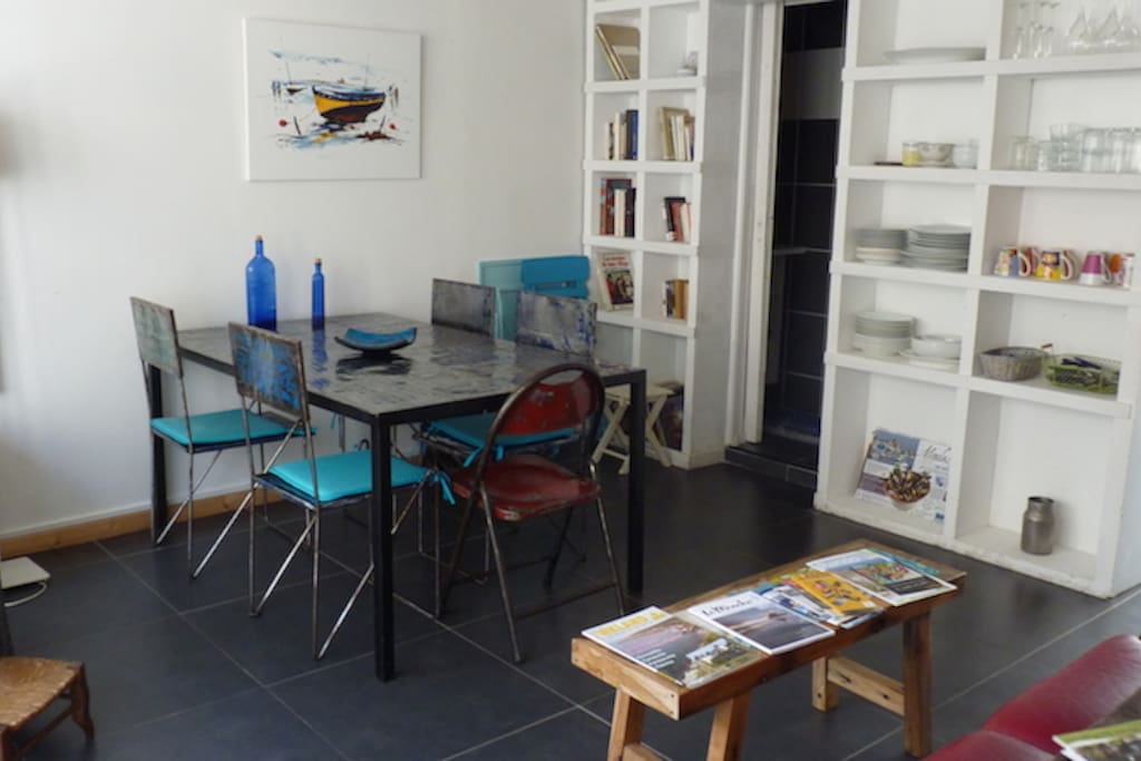 Étagères vaisselle et accessoires coin cuisine, entrée cuisine sur la droite.