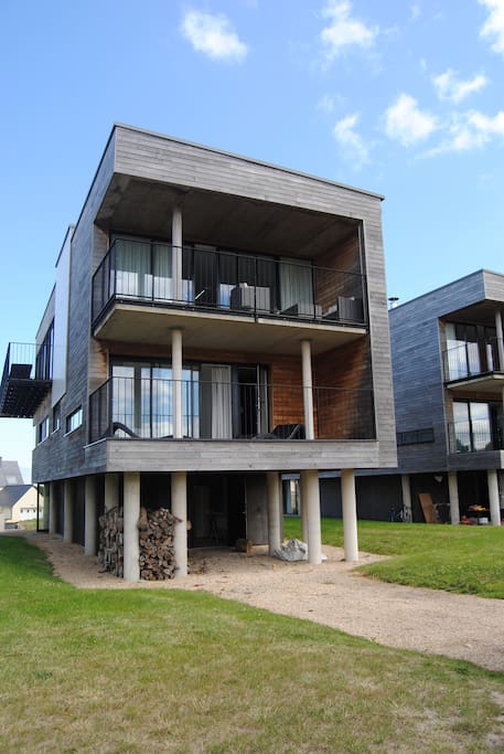 Balcon au Sud . Au détour d’un chemin, quatre maisons sur pilotis imposent fièrement leur ligne contemporaine, dans leur habit de bois qui sied si bien au paysage