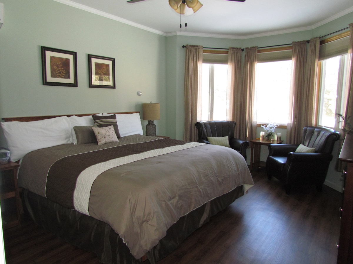 Master bedroom with king bed, leather chairs, dresser, flat screen TV, DVD, closet, and ensuite bathroom.