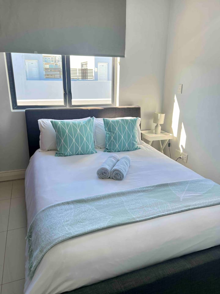 Una cama con colchón de espuma viscoelástica, aire acondicionado y persianas oscuras en el  dormitorio para mayor comodidad.