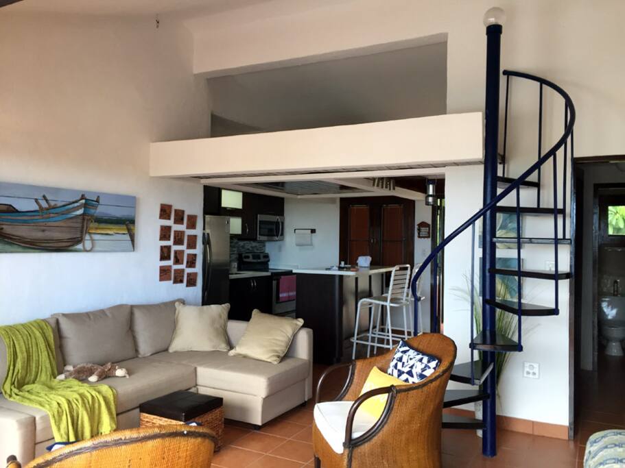 Escaleras suben a mezzanine con cama queen