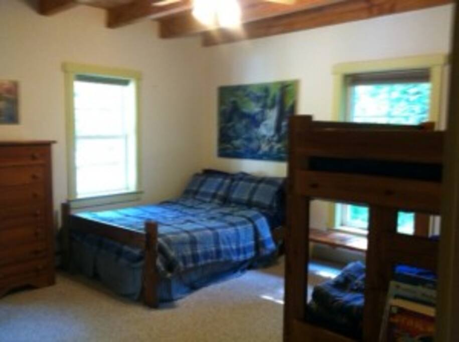 Room with a set of bunkbeds and 1 double bed