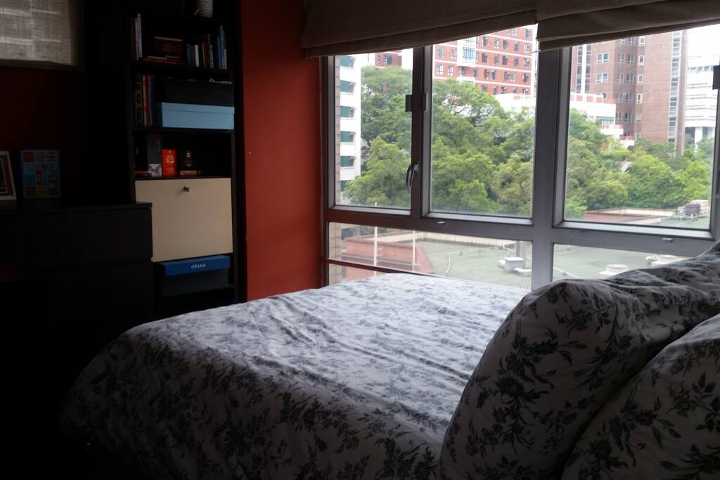 Queen size bed with a duvet and four pillows in a bright room (curtains available). Storage available for your luggage, wardrobe with hanging rail, silent aircon.