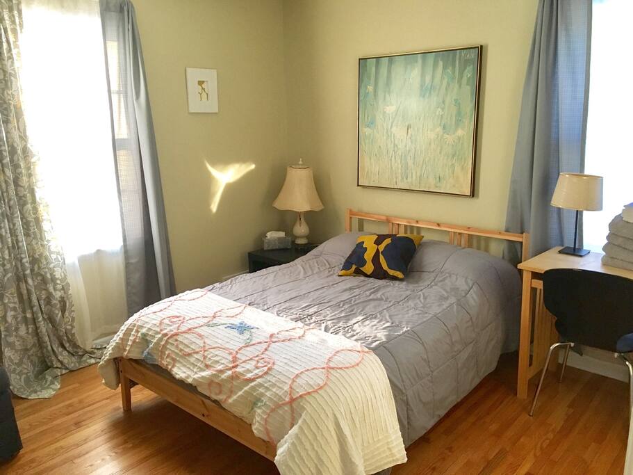 This is the larger of the two bedrooms. It has a closet, double bed, small desk and sitting chair. It has great natural light and hardwood floors.
