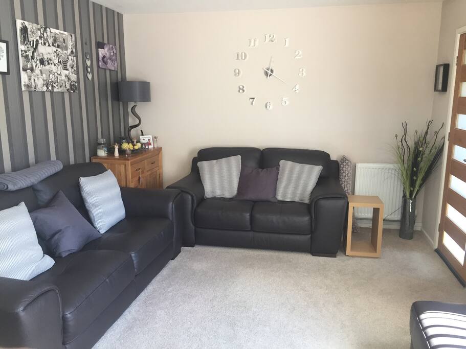 Living room is designed for comfort with electric fire, leather sofas and views of Portmeirion.