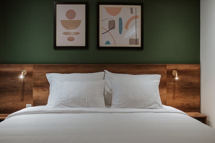 ملاذ معاصر مع سرير كينج، وستجد تلفزيونًا ذكيًا وخزانة ومكيف هواء وفن حديث وجدار أخضر نابض بالحياة!