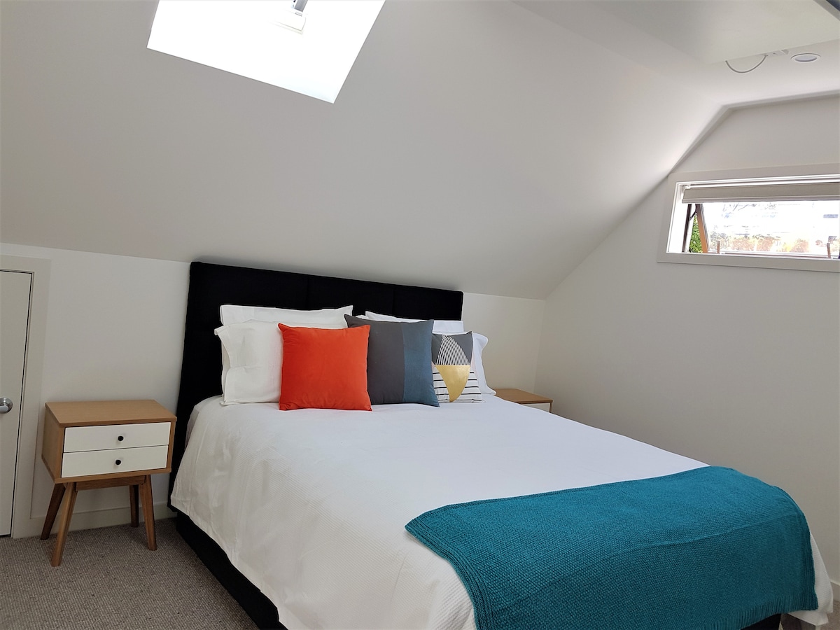 Upstairs bedroom with solar-powered skylights and blinds