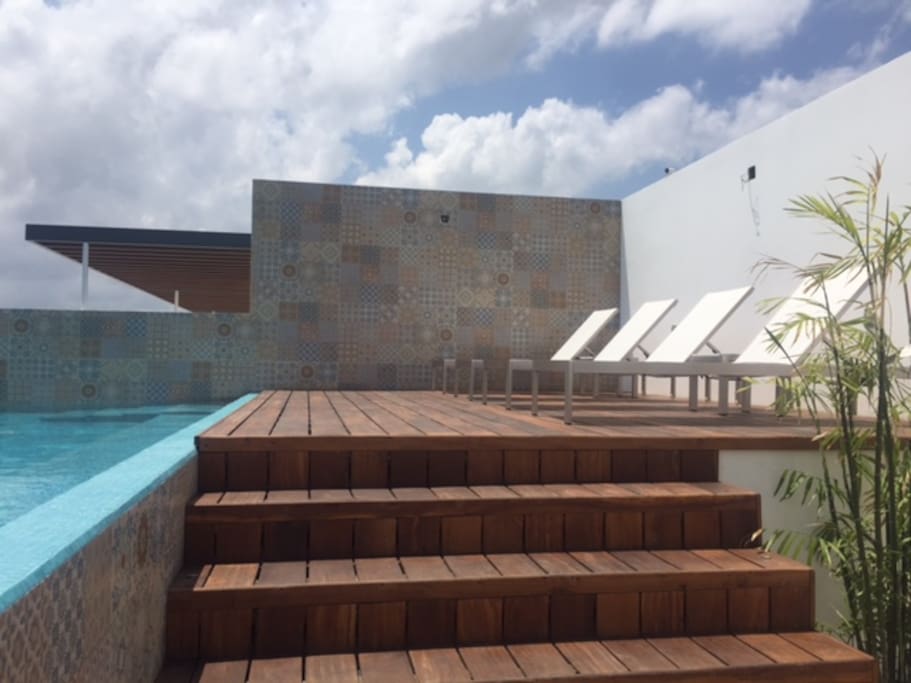 Solarium de madera junto a la alberca en azotea