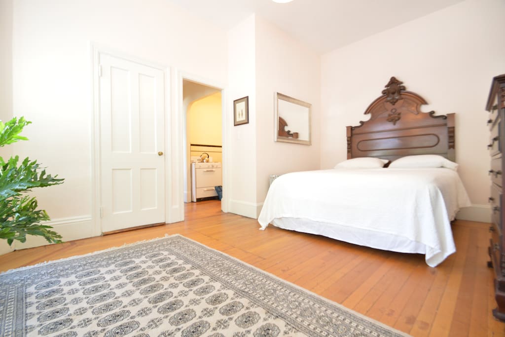 bedroom features a queen sized pillow top mattress bed with high quality cotton linens, antique headboard, dresser, closet, seating area, and luggage rack