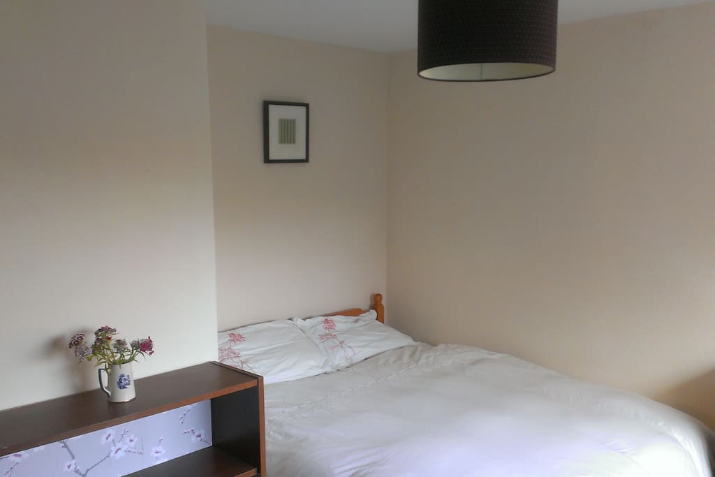 Double bed, beside table and bookshelf