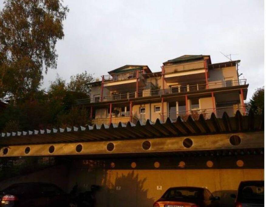 Außenansicht von unten. Die Wohnung oben links. Hanglage. Von oben 1.Obergeschoß