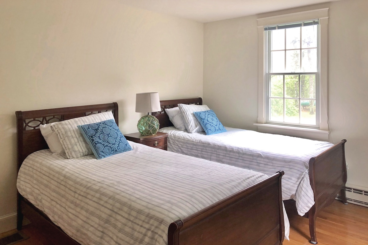 Chambre avec lits jumeaux, deux commodes, un bureau et un placard