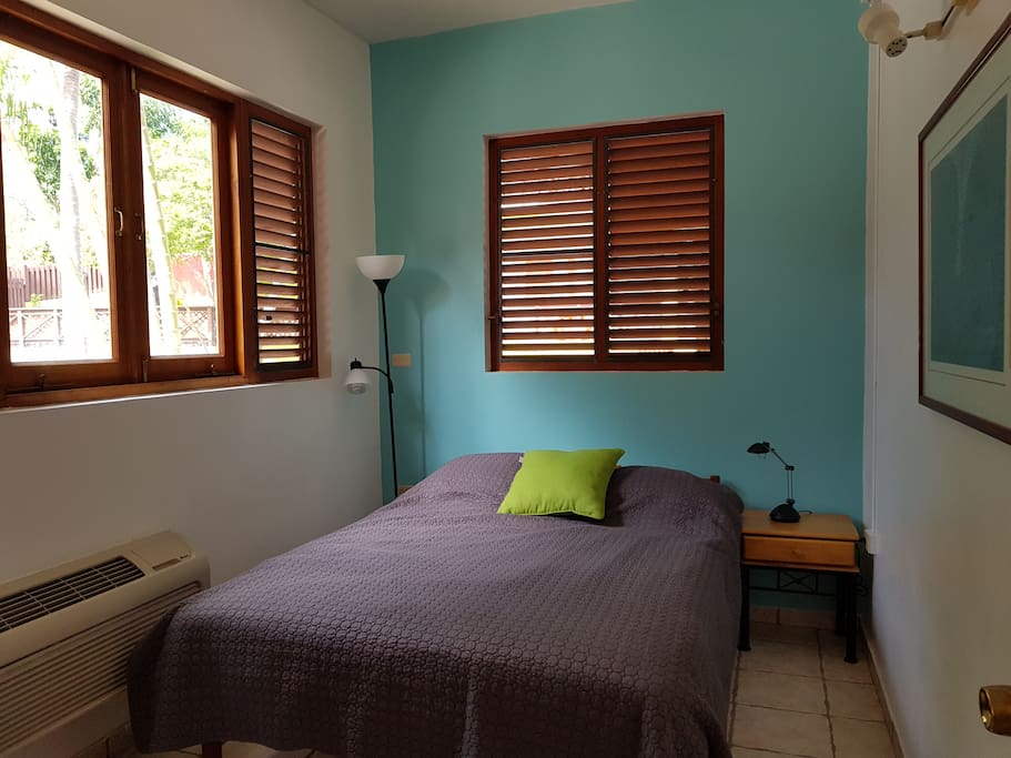 1st room with a queen size bed, fan ceiling, AC, and a closet.