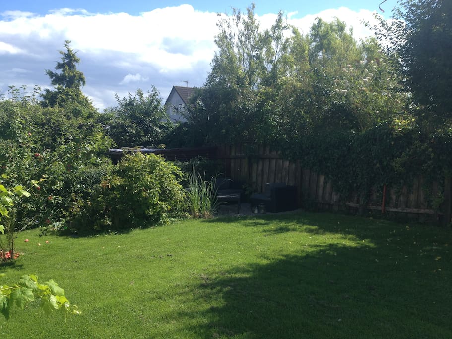 Our garden with cosy corners and trampolin for childreen.