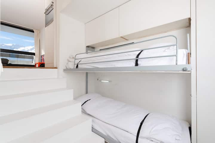 Camas individuales de tamaño completo separadas del espacio principal por una puerta corrediza