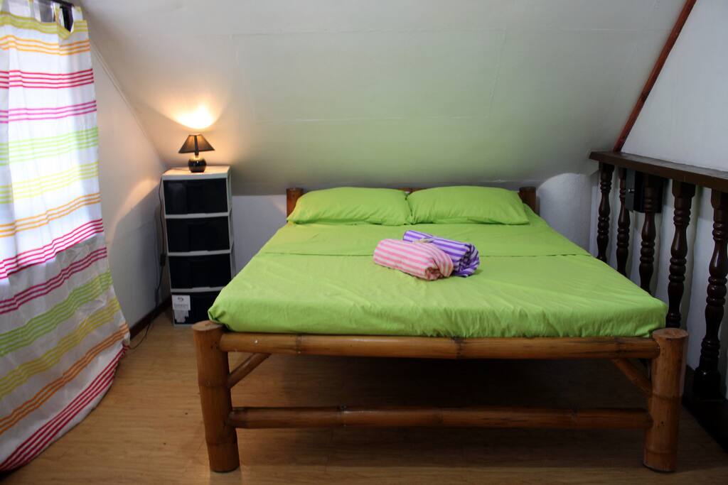 The bedroom has AC and fan, a queen sized bed and bedside lamp with drawers. The room has AC and a fan also.