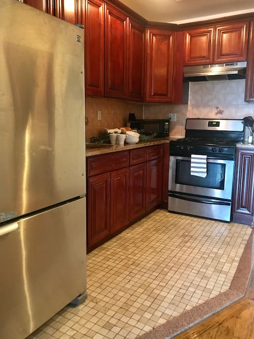 Kitchen equipped with gas stove and dishes, salt, pepper, and cooking oil, pots, pans, French press coffee maker
