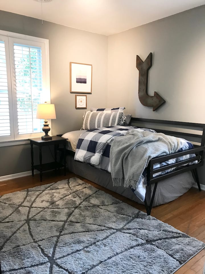 Este acogedor dormitorio ofrece un lugar agradable para relajarse y disfrutar de una noche de descanso, con un colchón de suelo convenientemente almacenado debajo de la cama para espacio adicional para dormir si es necesario.