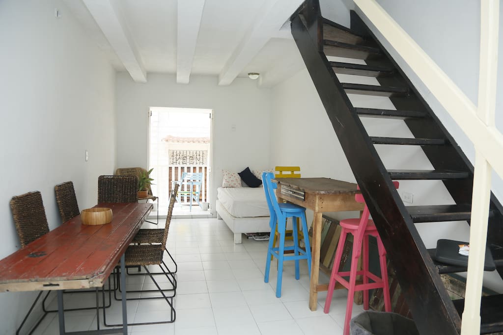 Large downstairs living room with worktop, table, daybed and street facing balcony.