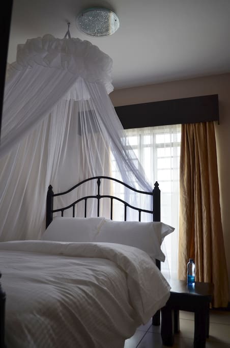 Bedroom 2: Comfortable double bed with a pleasant view of the city.