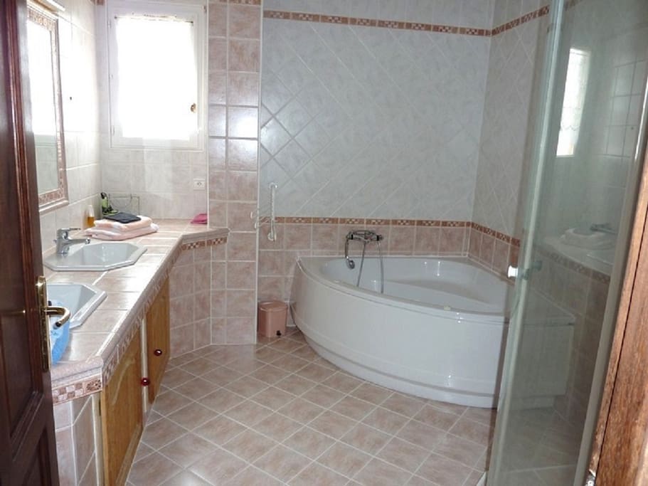 Salle de bain avec baignoire balnéo et douche spacieuse