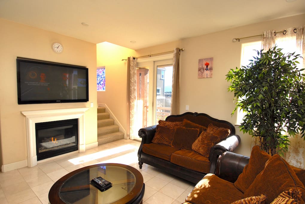 Comfy sofa and love seat facing the cozy fireplace and large screen cable TV