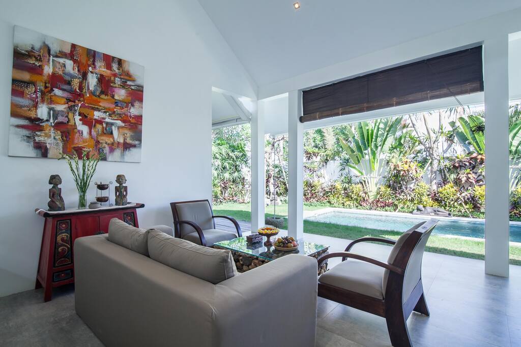 Open living room with a view on the private pool and garden