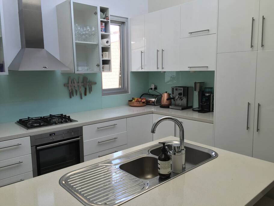 Kitchen with stone benchtops, dishwasher and coffee machine.