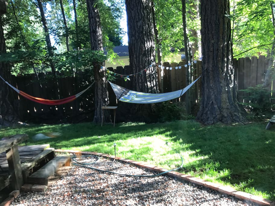 This is the private back yard with a small stream running through, there is a deck a grill and two hammocks for you to lounge in.