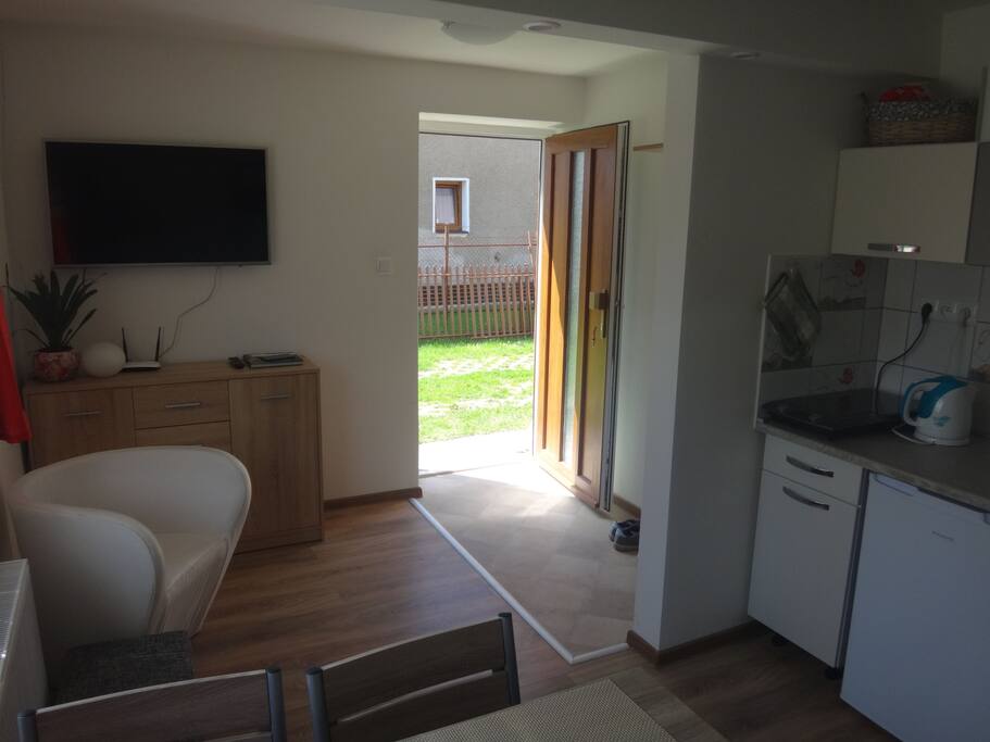 Obývacia miestnosť spojená s kuchyňou a vchodom do apartmánu